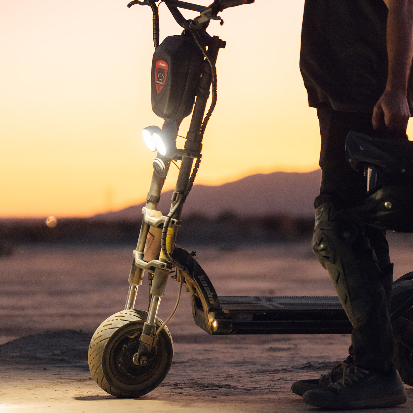 Evening shot of Kaabo Warrior 11 electric scooter with its bright headlight on, ready for a safe night ride.