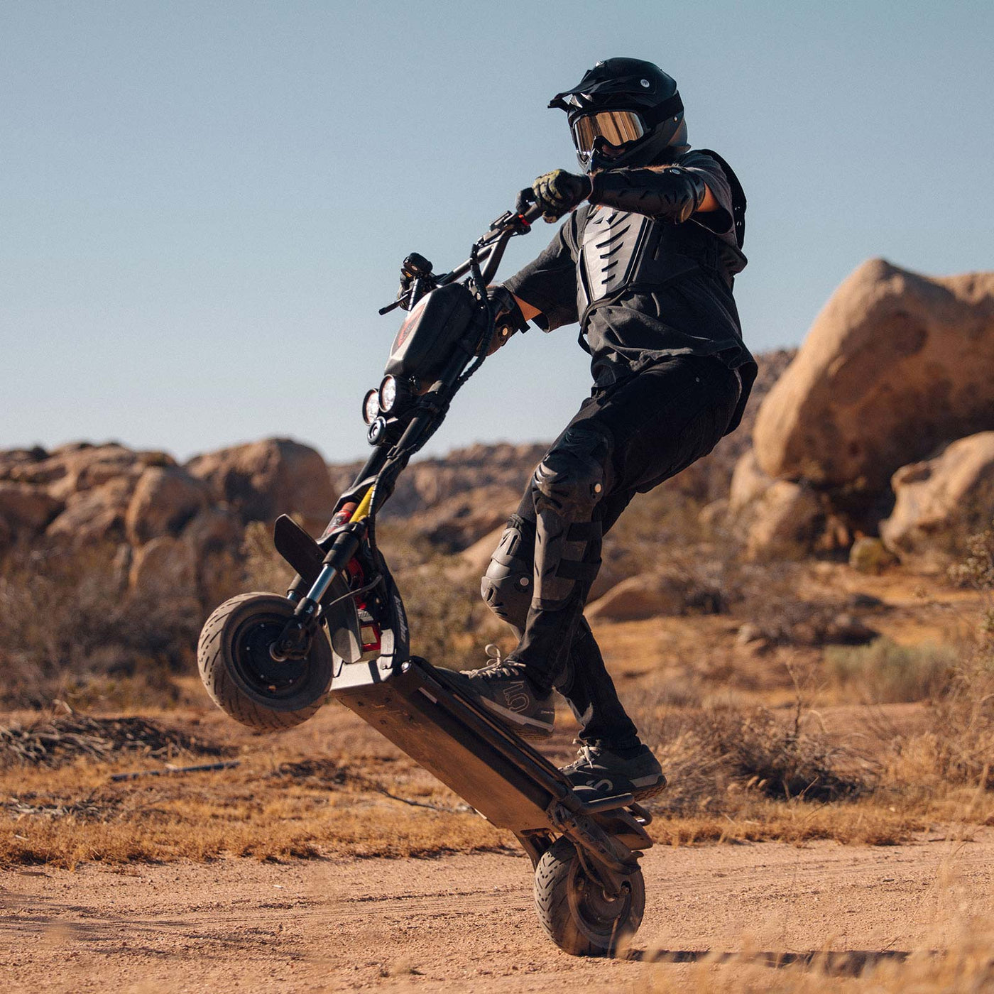 Adventurous off-road wheelie performed on the rugged Kaabo Warrior 11 Pro+ electric scooter, showcasing its powerful dual-motor capabilities and robust construction.